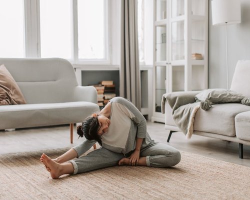 Person doing light yoga stretching in home garden to stay active